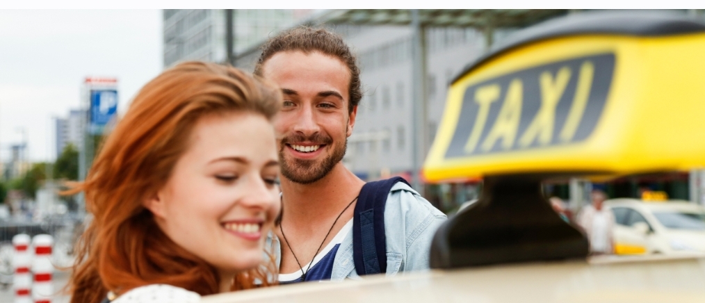 Passagers heureux à côté d’un taxi à Luxembourg